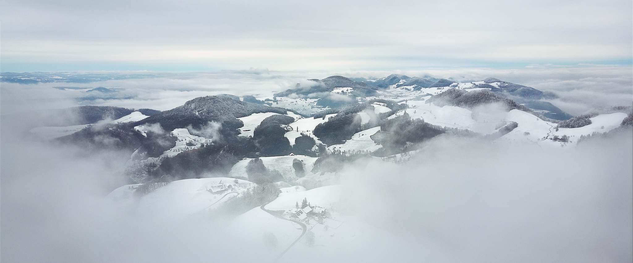 schneebedeckte Hügel im Nebel